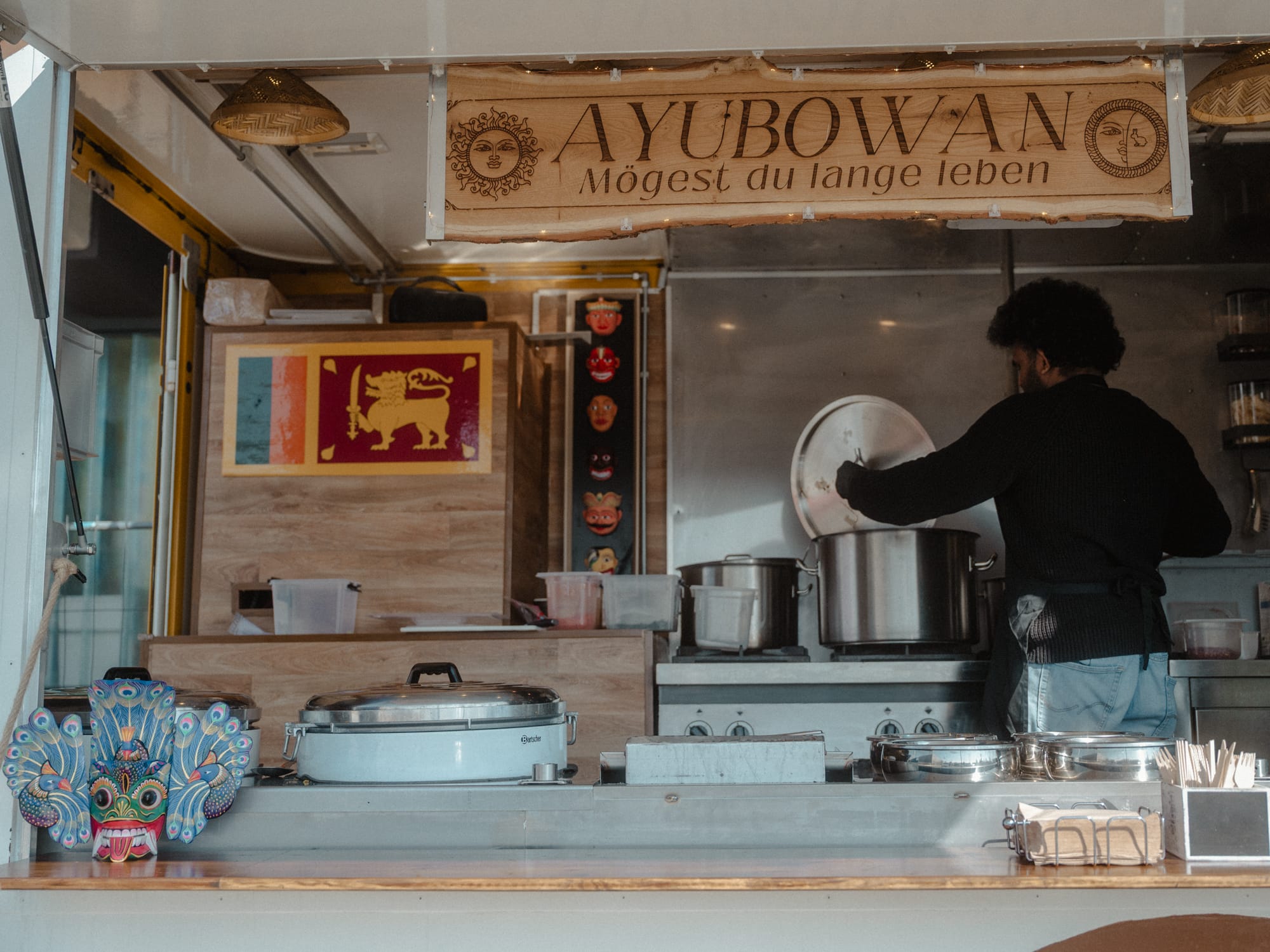 Blick in den Ceylon-Fusion-Foodtruck mit Flagge und Ayubowan-Schild