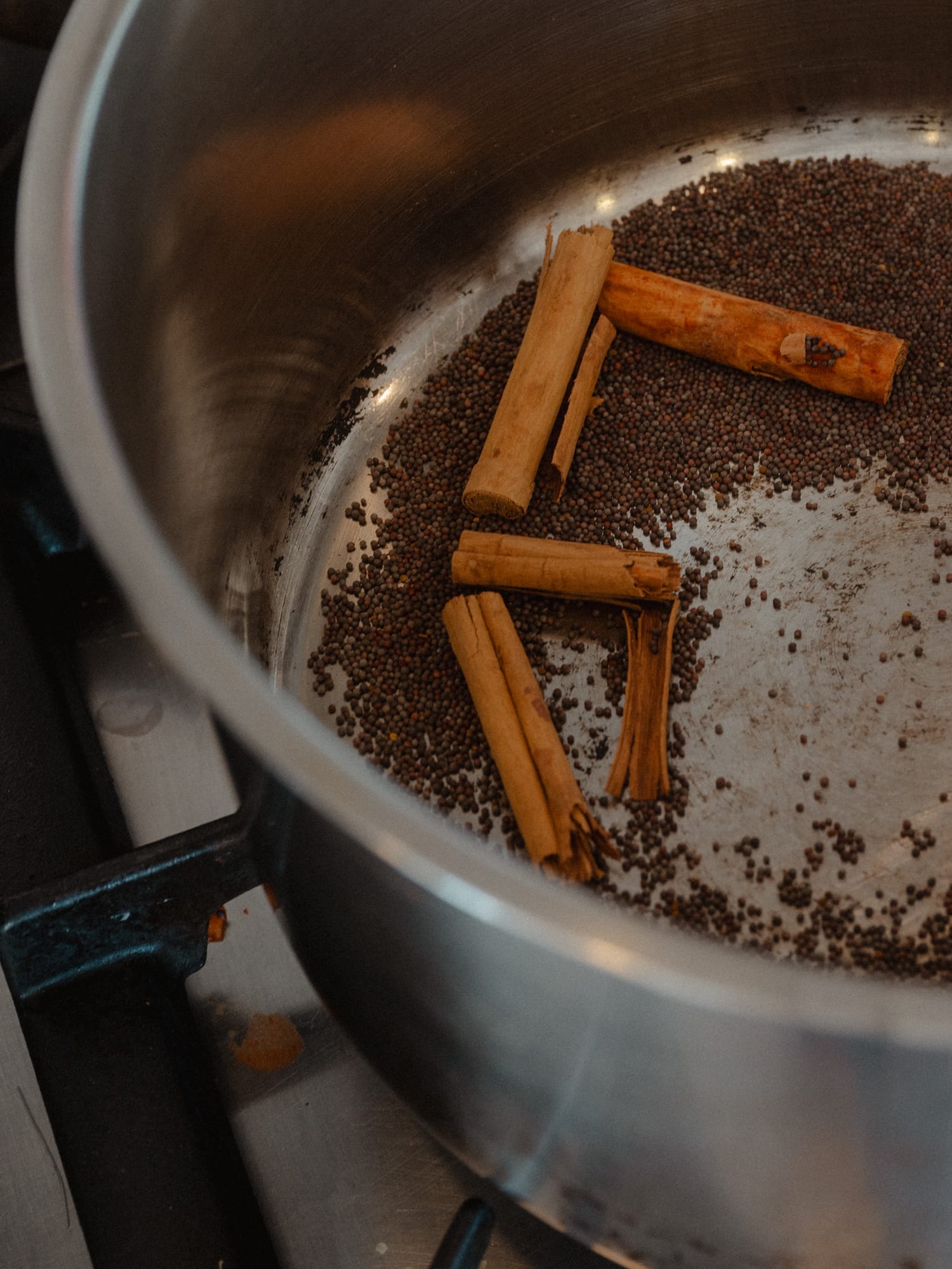 Zimtstangen und Senfkörner werden im Topf geröstet